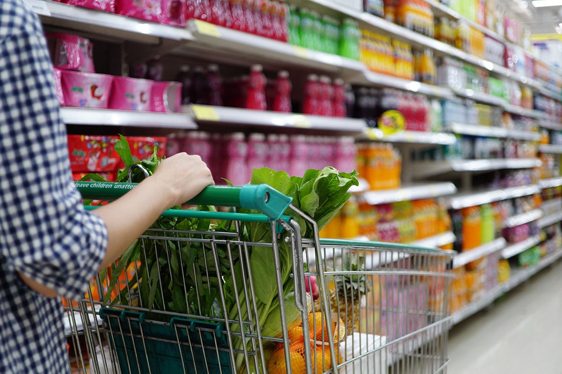 Women pushing shopping trolly in the supermarket aisles shopping concept Women pushing shopping trolly in the supermarket aisles shopping concept