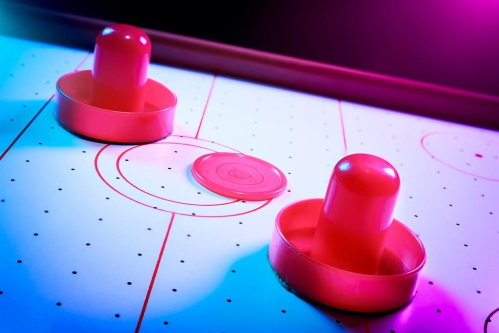 Confused By Snooker Gear That Promises Precision But Plays Like Plastic? Here’s Where To Find The Best Cue Sports Equipment In The UK That Actually Performs Air hockey table with dramatic lighting on a dark background